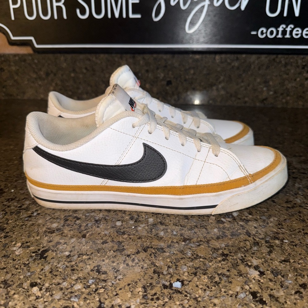 Nike women’s White and Black Sneakers with Gold Accents